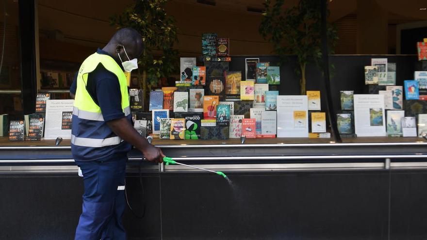 Un trabajador desinfecta el entorno de una librería en Londres