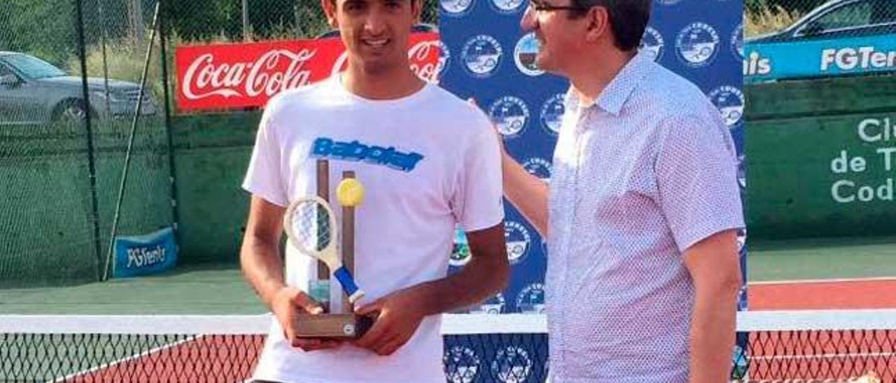 Yayo recibe el trofeo de campeón gallego infantil de tenis.