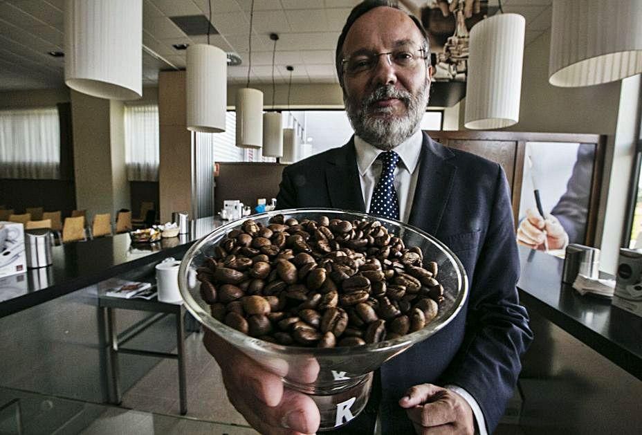 Carlos Manuel Rodríguez, con un recipiente con granos de café en la factoría de Tineo.