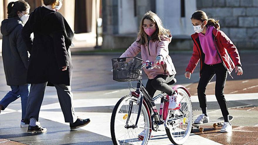 Carmen Blanco, con patinete, y Alcázar Mozo, con la bici de Reyes, ayer, en la plaza del Fresno. | Luisma Murias