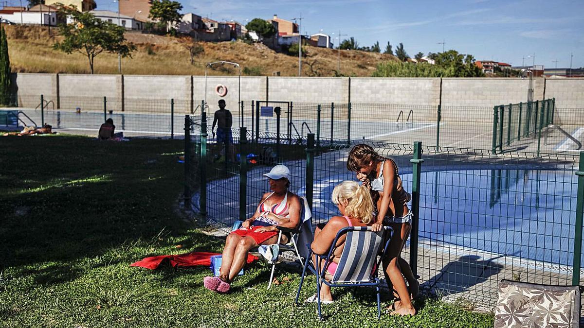 Varias personas disfrutan del sol en la piscina de Higueras