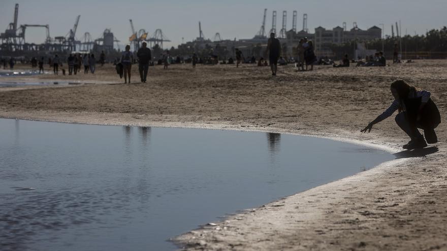 Varias personas disfrutan del buen tiempo en la playa.