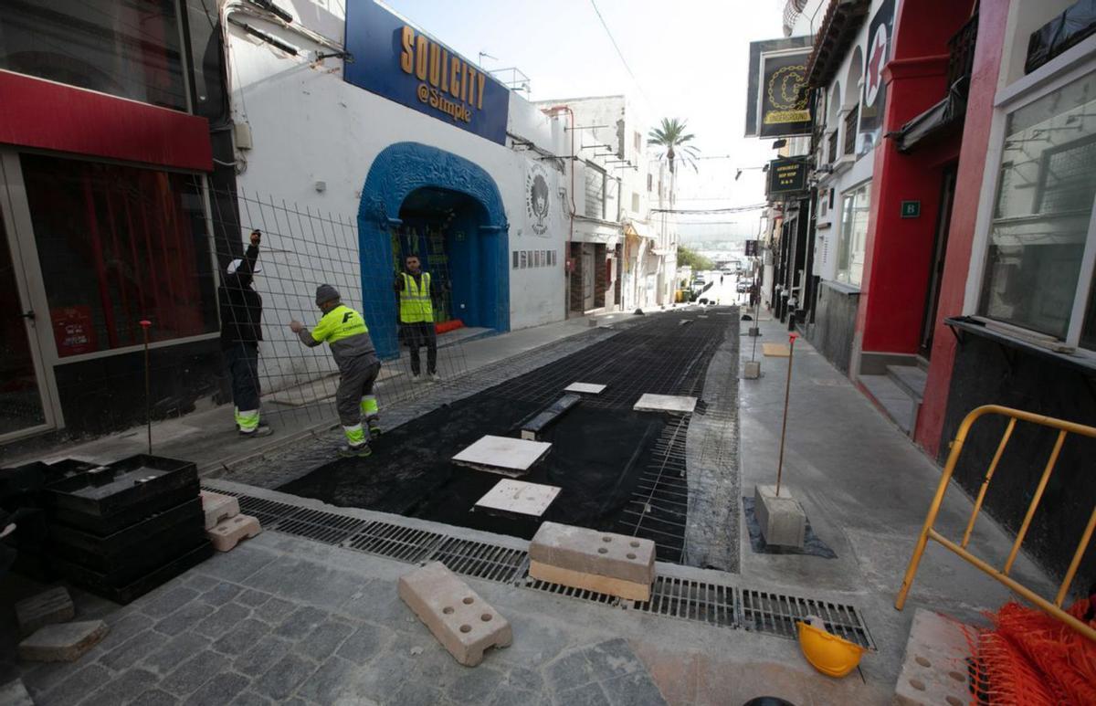 El pavimento se ha empezado a instalar en los laterales de la calle Santa Agnès. A la derecha, tres operarios, ayer, instalan una malla de hierro sobre el asfalto. | VICENT MARÍ