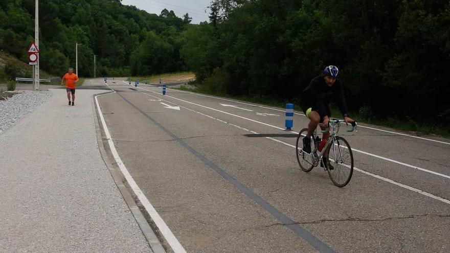 Un corredor y un ciclista usando el circuito recién inaugurado en la Pola.