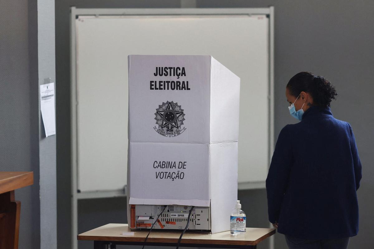 A Brazil citizen passes by a voting booth for Brazils election, in Lisbon