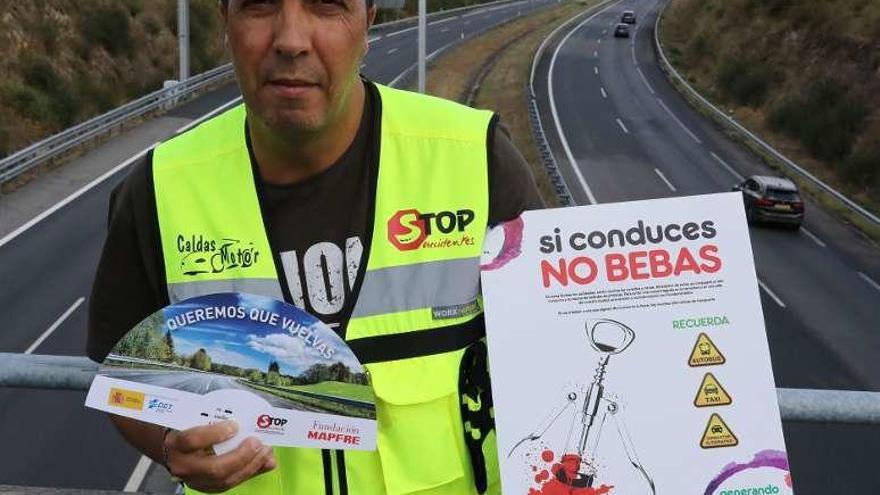 Benito Bouzada posando con un cartel y con un abanico alusivos a campañas de concienciación de Stop Accidentes. // J.Regal