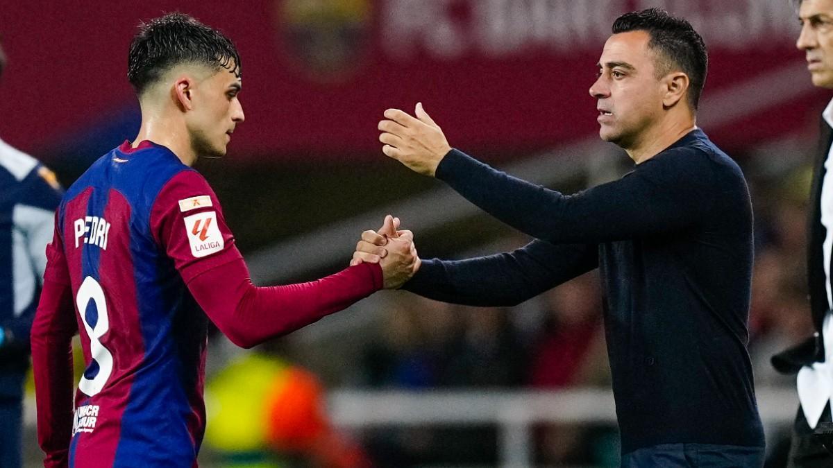 Pedri y Xavi se dan la mano tras la sustitución del canario en el encuentro del Barça ante la Real Sociedad en Montjuic