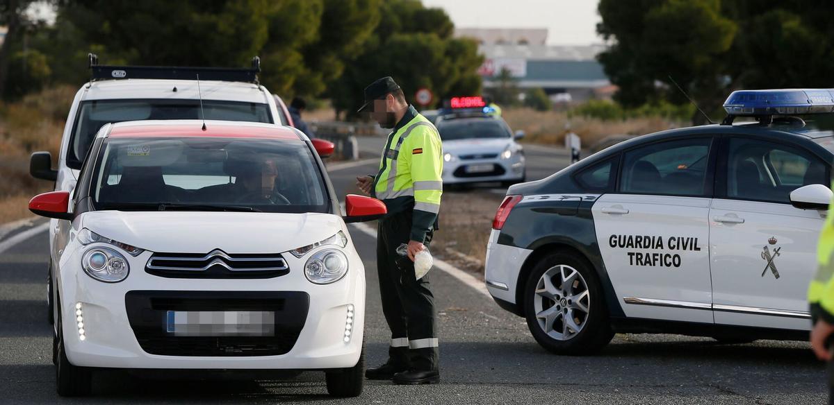 Un agente de la Guardia Civil da el alto a un vehículo en un control de tráfico