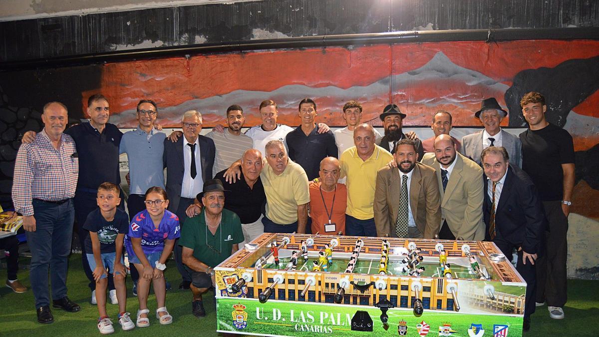Foto de familia de varios de los asistentes frente al futbolín del Estadio Insular.