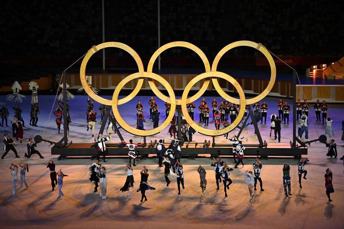 Actores de la ceremonia de inauguración componen los aros olímpicos, en el estadio olímpico de Tokyo.