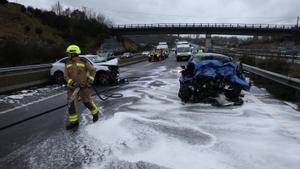 Los bomberos trabajan en la autovía de la A-52 junto a los amasijos en los que han quedado convertidos los dos vehículos que han chocado frontalmente este sábado, en la provincia de Pontevedra.