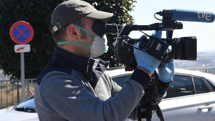 Un profesional de la comunicación, con mascarilla delante del hospital de A Coruña.