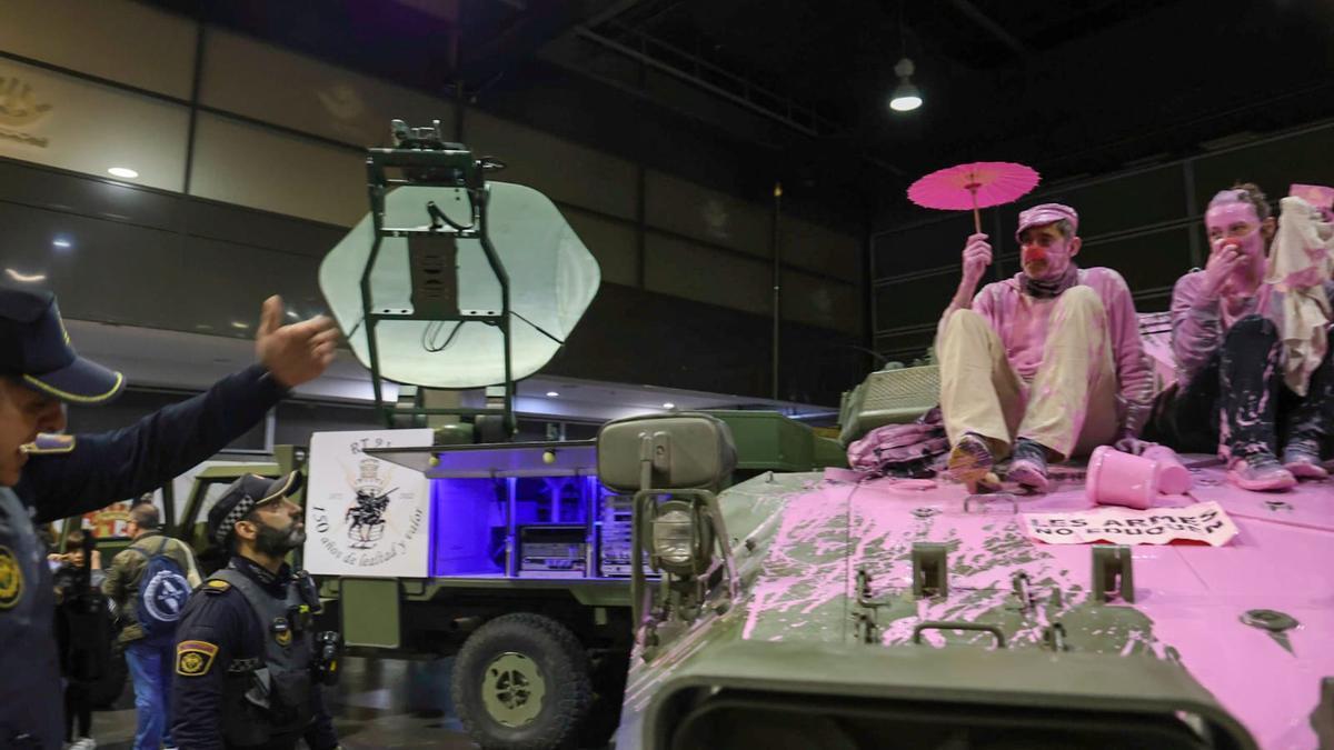 Unos pacifistas rocían pintura rosa sobre una tanqueta en Expojove: &quot;Las armas no educan&quot;.