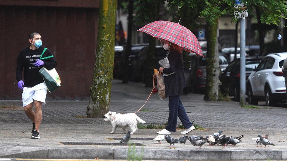 Dos transeúntes bajo la lluvia, en Barcelona, el pasado 10 de mayo