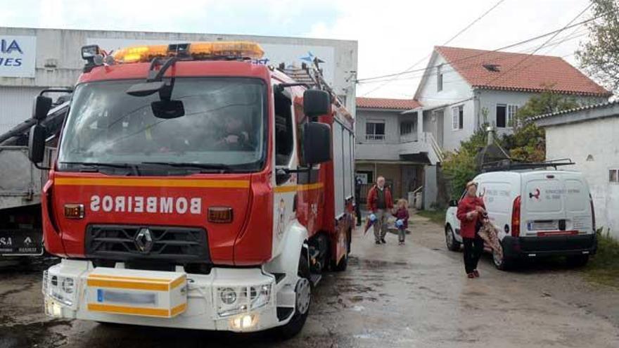 La unidad de bomberos que acudió a sofocar las llamas, con la casa al fondo. // Rafa Vázquez