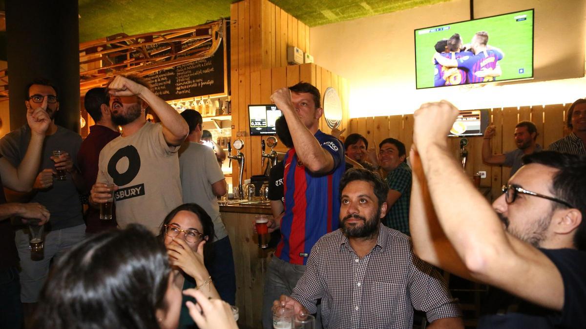 Seguidores del Barça miran un partido dentro de un bar