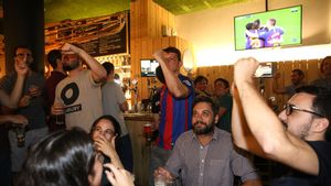 Seguidores del Barça miran un partido en un bar.