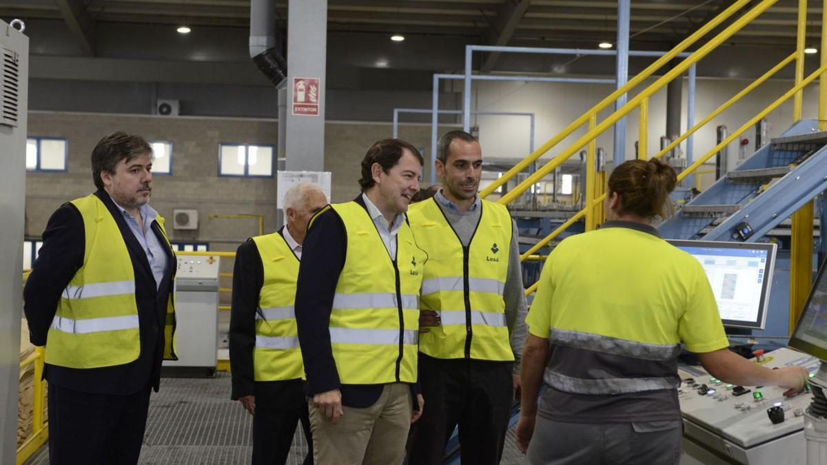 Mañueco conversa con una operaria en la planta de tableros. | J. A. G.