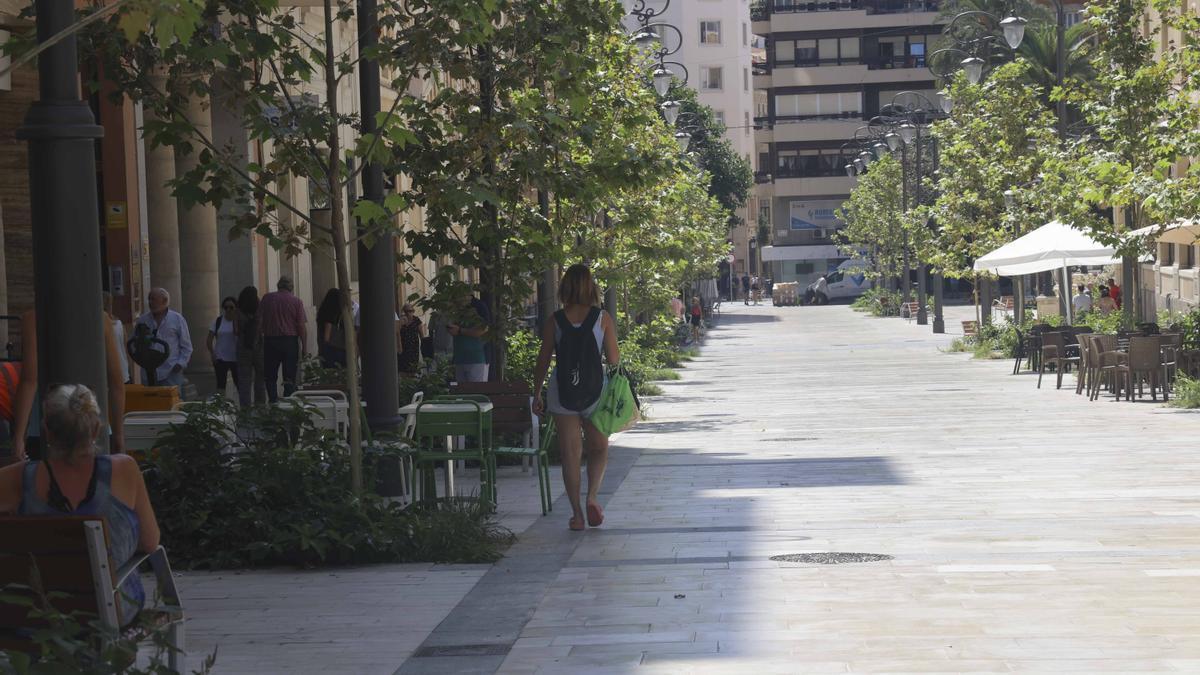 Una mujer caminando por zonas de sombra en el centro de Alicante este lunes.