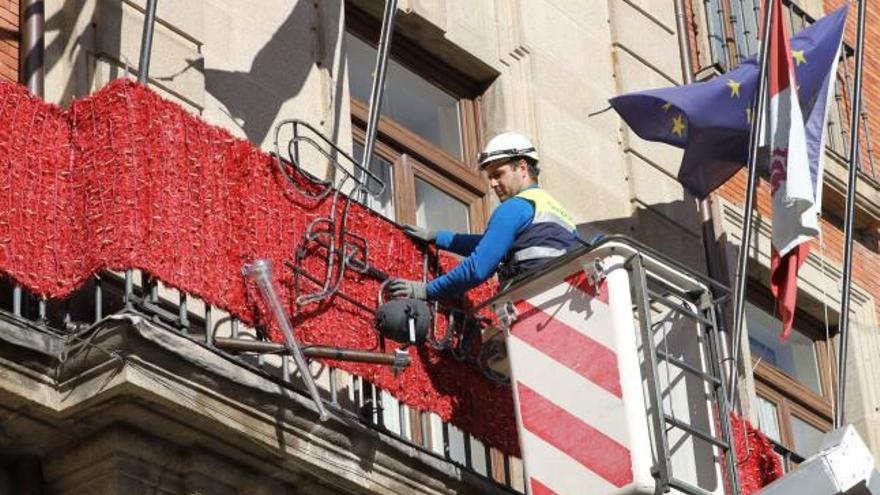 Un operario coloca las luces de Navidad en el Ayuntamiento.