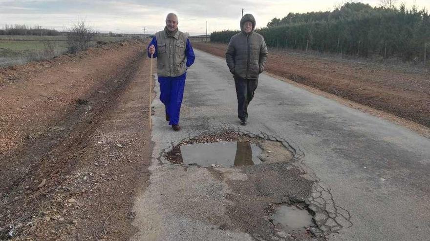 Dos personas caminan por la vía que enlaza Paladinos con Pobladura.