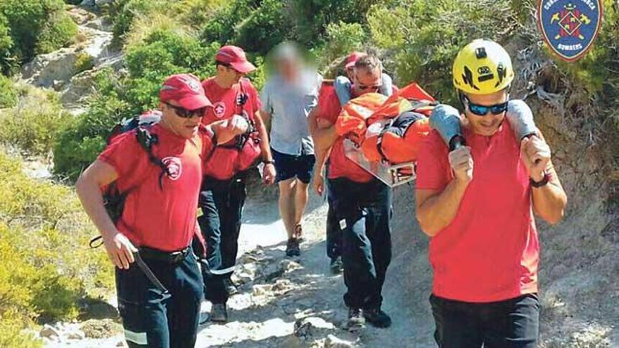 Los bomberos, durante el rescate de la mujer herida.