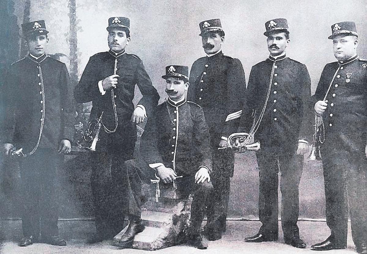 Retrat d’estudi de la Companyia Municipal de Bombers de Girona amb els seus uniformes de gala i cornetes, l’any 1907.