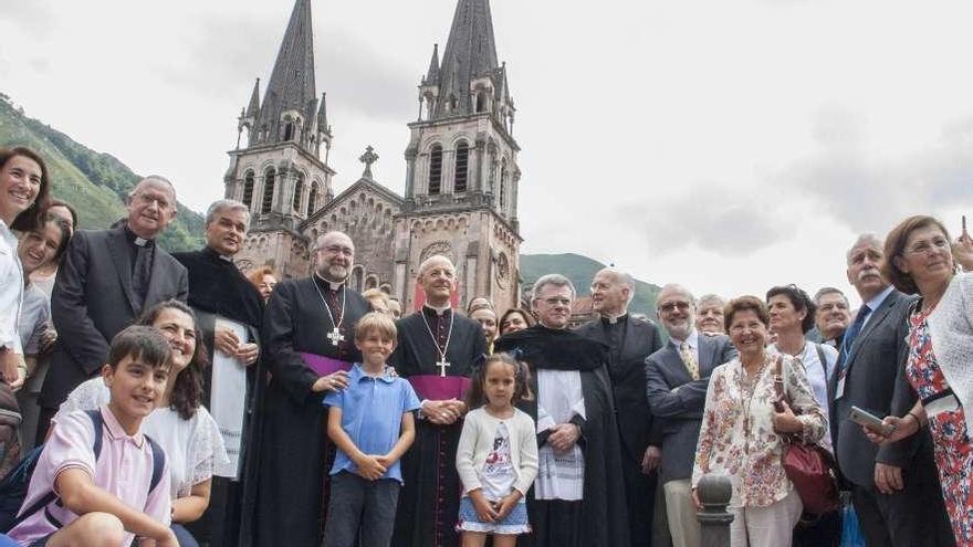 El arzobispo de Oviedo y el prelado del Opus Dei, en el centro, junto al abad de Covadonga, otros sacerdotes y un grupo de participantes en la misa, ante la basílica de Covadonga.