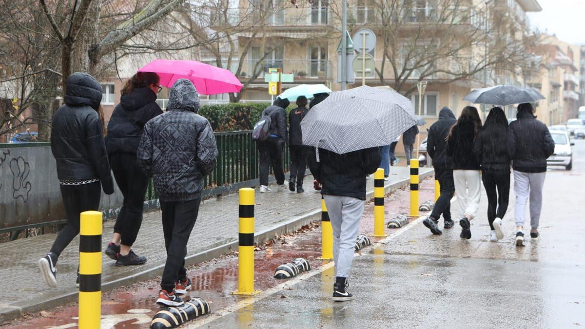 Personas caminan con paraguas bajo la lluvia