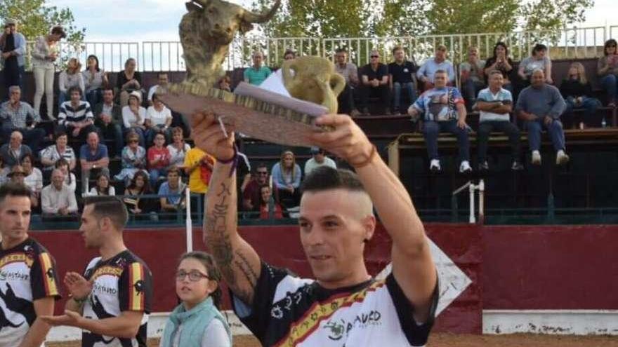 El ganador del recorte recibe el trofeo en la plaza de toros de El Pego.