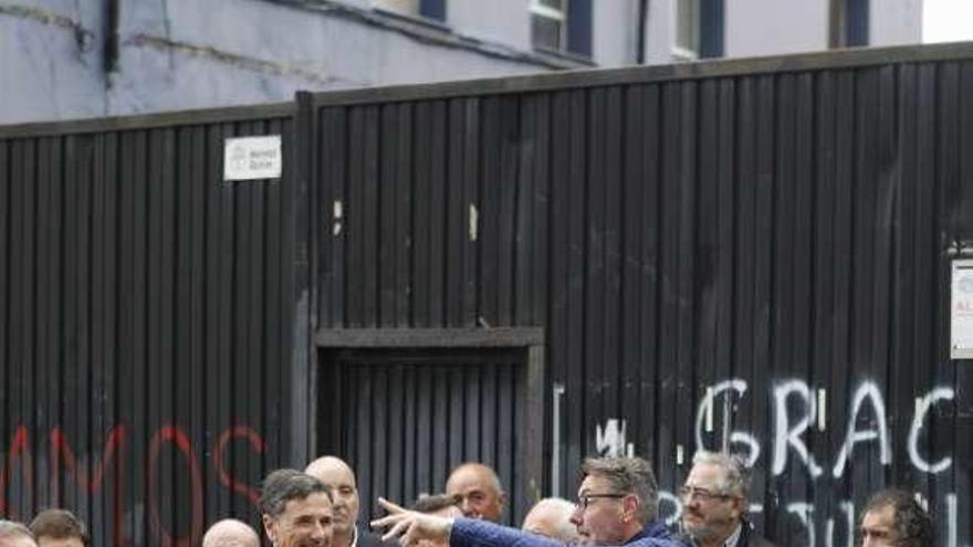 El diputado regional de Podemos Enrique López conversa con extrabajadores de Naval Gijón a la puerta de la empresa.