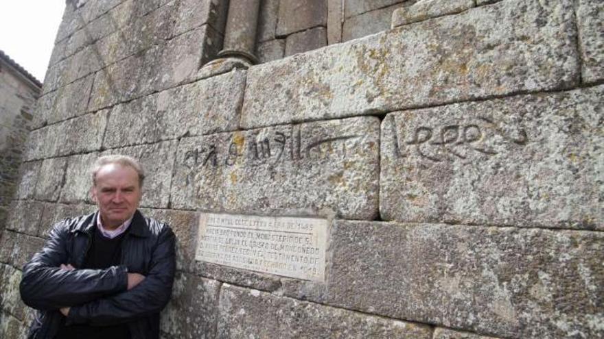 González Alén posa delante de la inscripción que recuerda la fundación monacal de la iglesia de Lalín de Arriba.  // Bernabé/Gutier