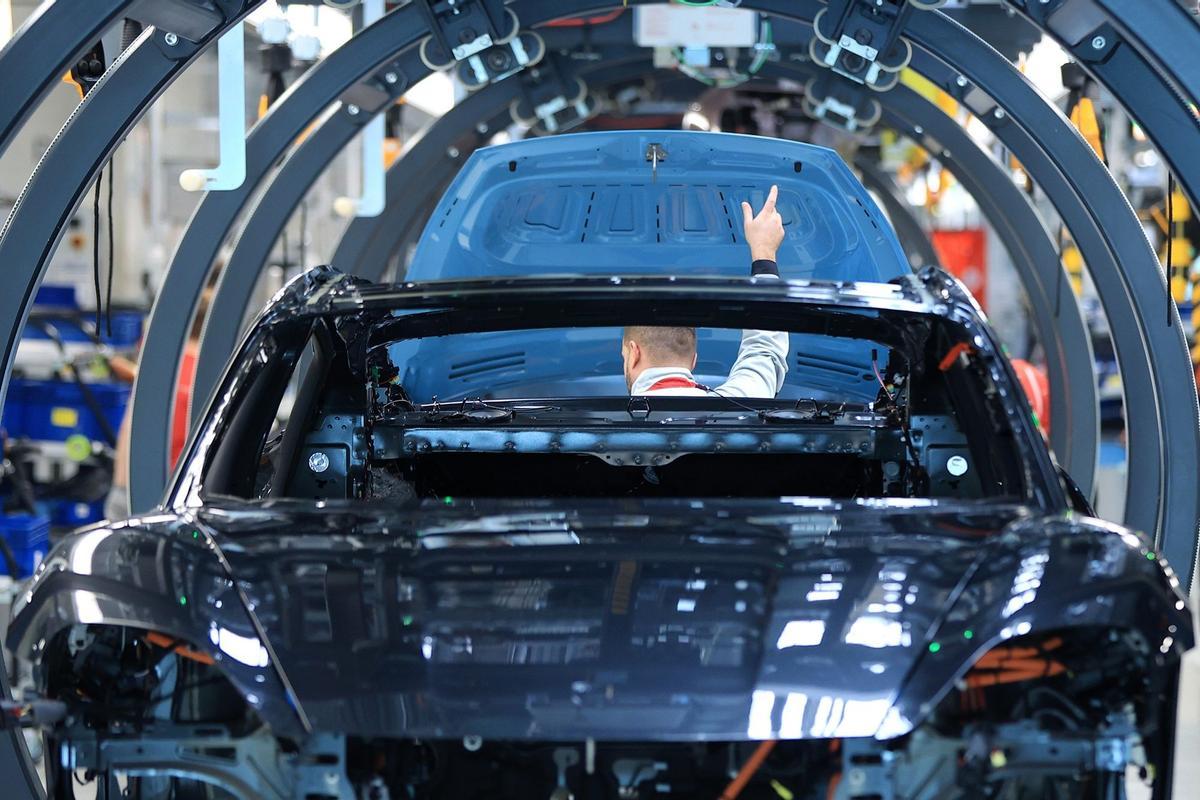 Los empleados trabajan en las carrocerías de los automóviles de lujo Porsche Taycan totalmente eléctricos en la línea de producción de la fábrica de Porsche AG en Stuttgart, Alemania.