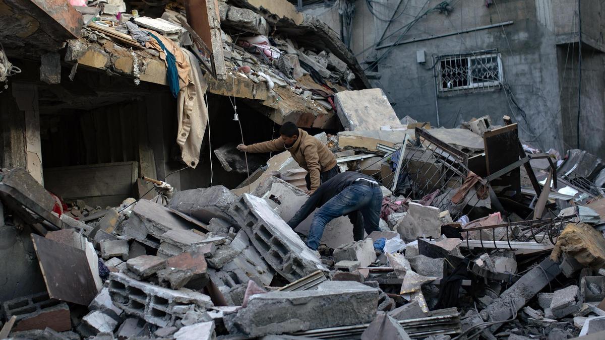 Palestinos buscan personas desaparecidas bajo los escombros tras un ataque aéreo israelí en Gaza.