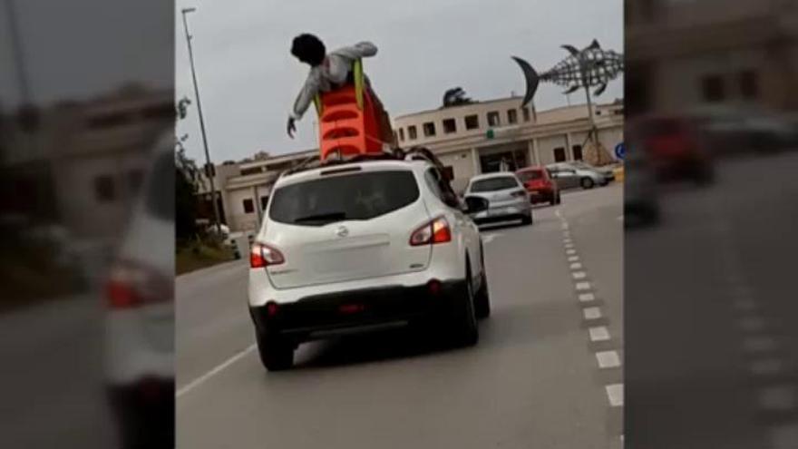 Circula sentado en un tobogán en el techo de un coche