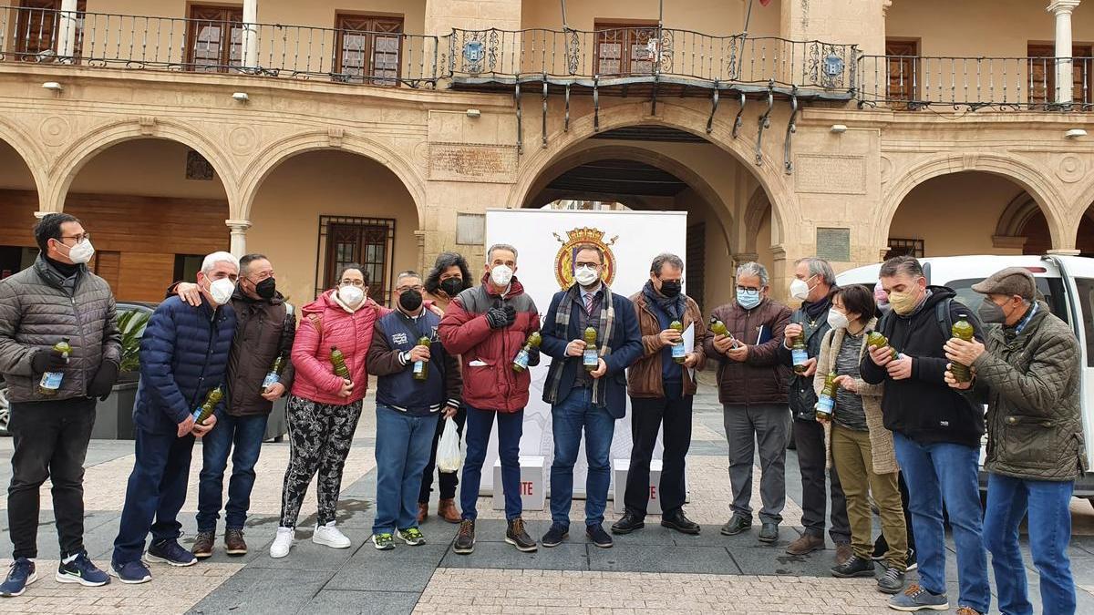 Diego José Mateos, Antonio Navarro y María Dolores Chumillas con los representantes de las organizaciones que han recibido el aceite, este jueves.