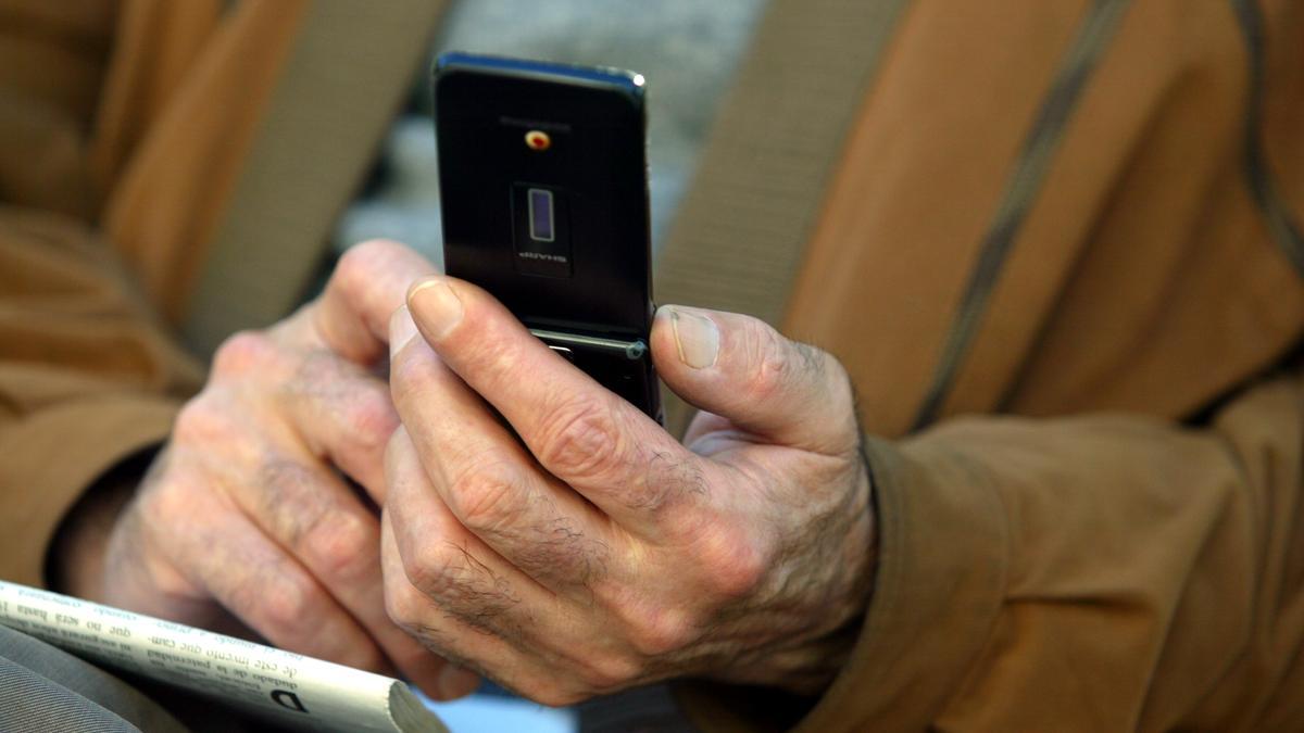 Un hombre con un teléfono en sus manos, en imagen de archivo.