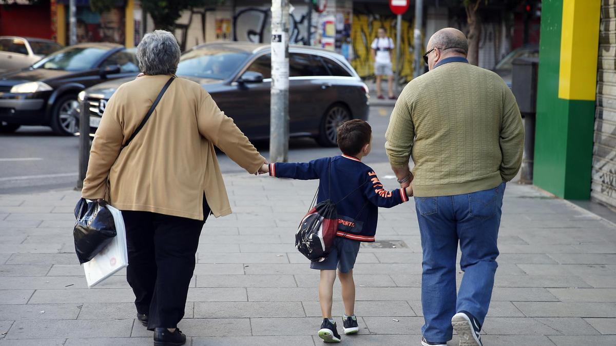 Dos abuelos pasean con su nieto.
