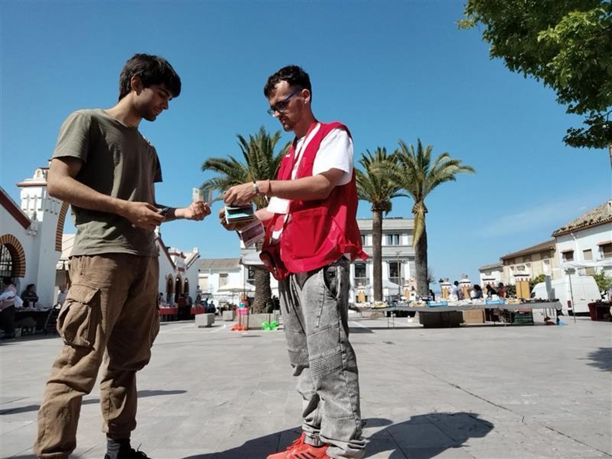 Un voluntario de Cruz Roja vende un boleto del Sorteo de Oro.
