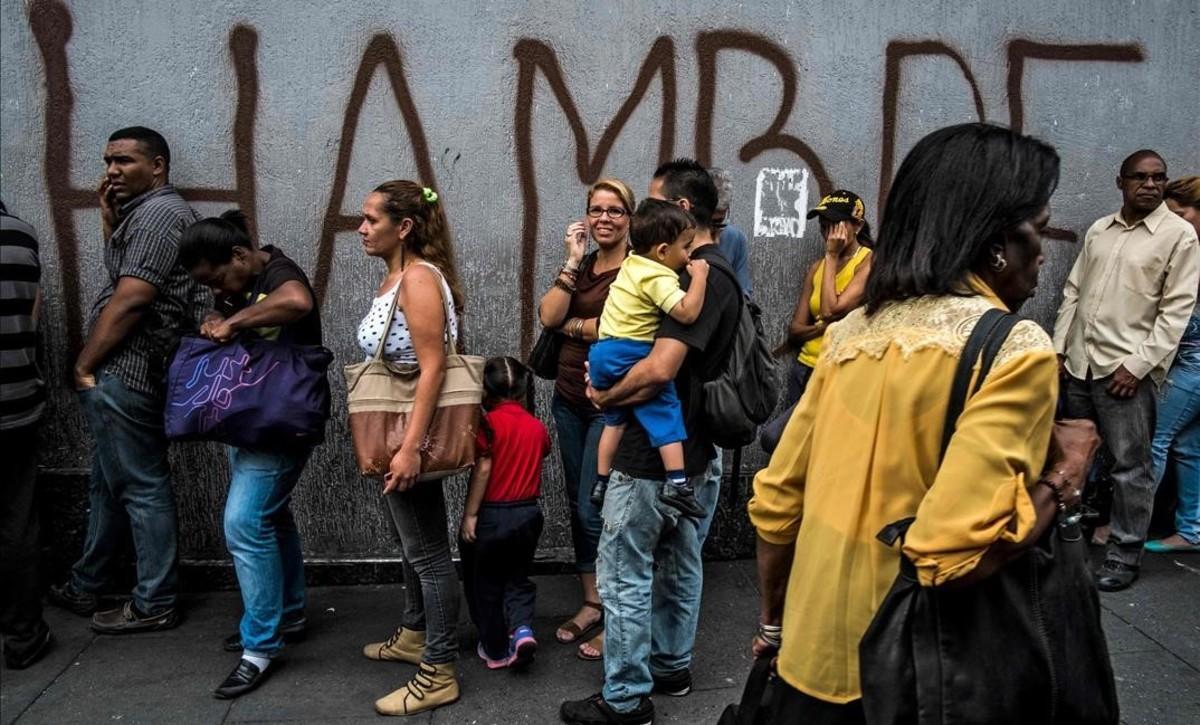 zentauroepp44426920 people queue next to a wall with a graffiti reading  hunger 180724111244