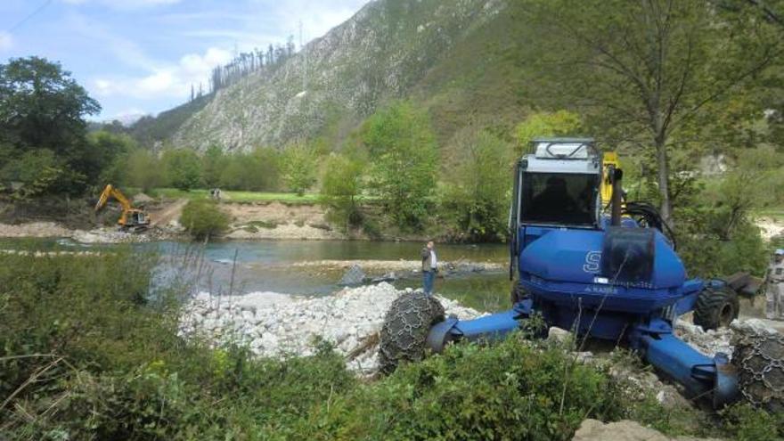 Las grúas que retiran los restos de la pasarela del Sella en Triongu, entre Arriondas y Ribadesella.