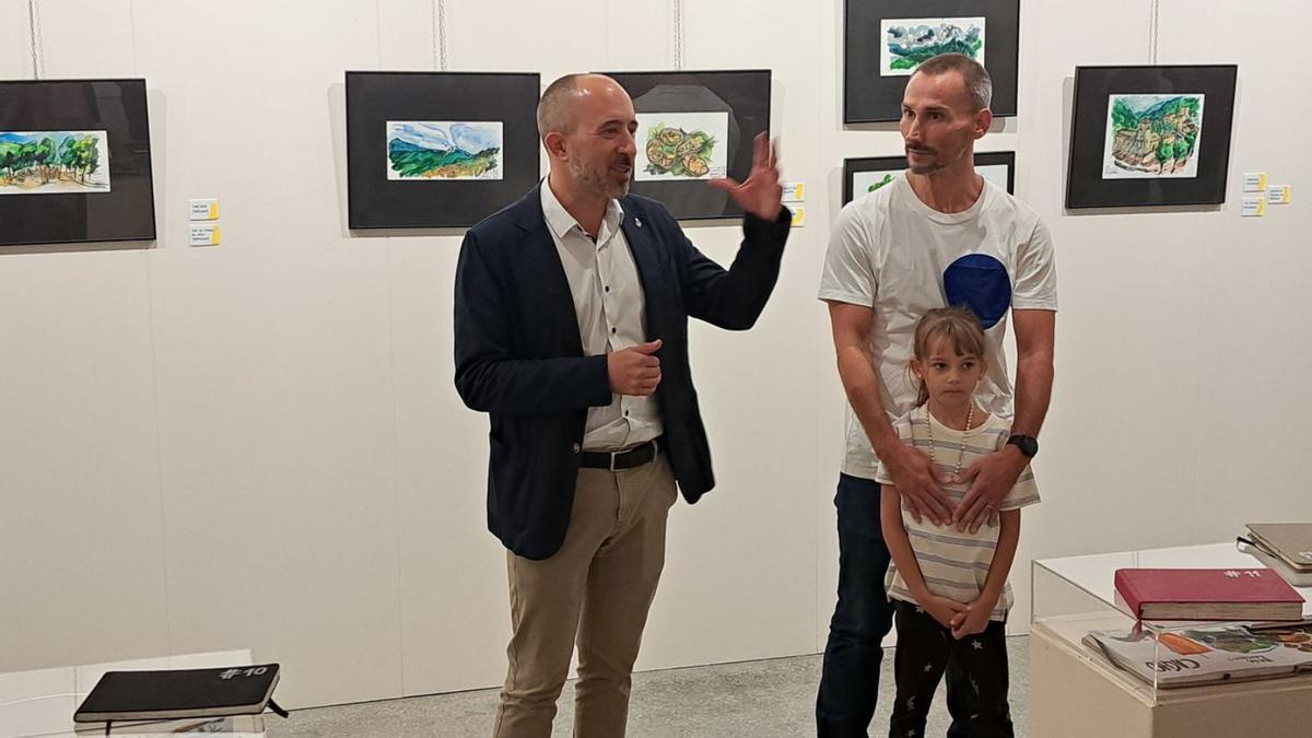 L’alcalde Marc Aloy amb l’autor Manel Gómez i la seva filla Mia, en un moment de la inauguració | GEMMA SANLLEHÍ