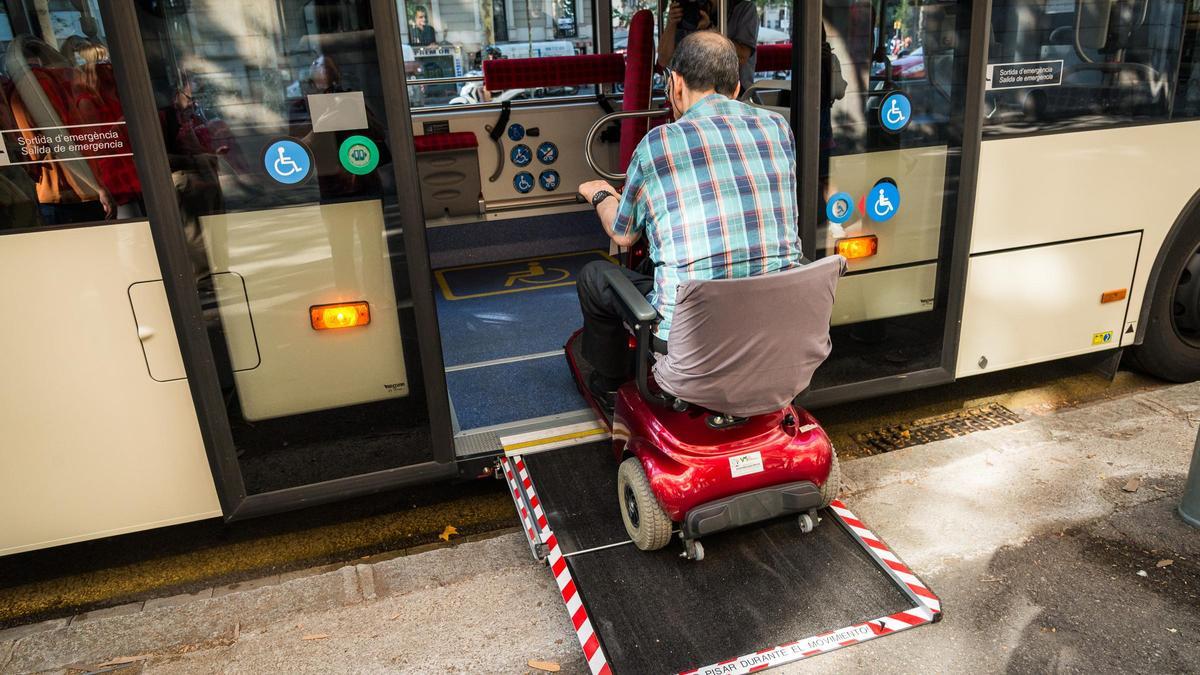Una persona con movilidad reducida sube a un bus de TMB