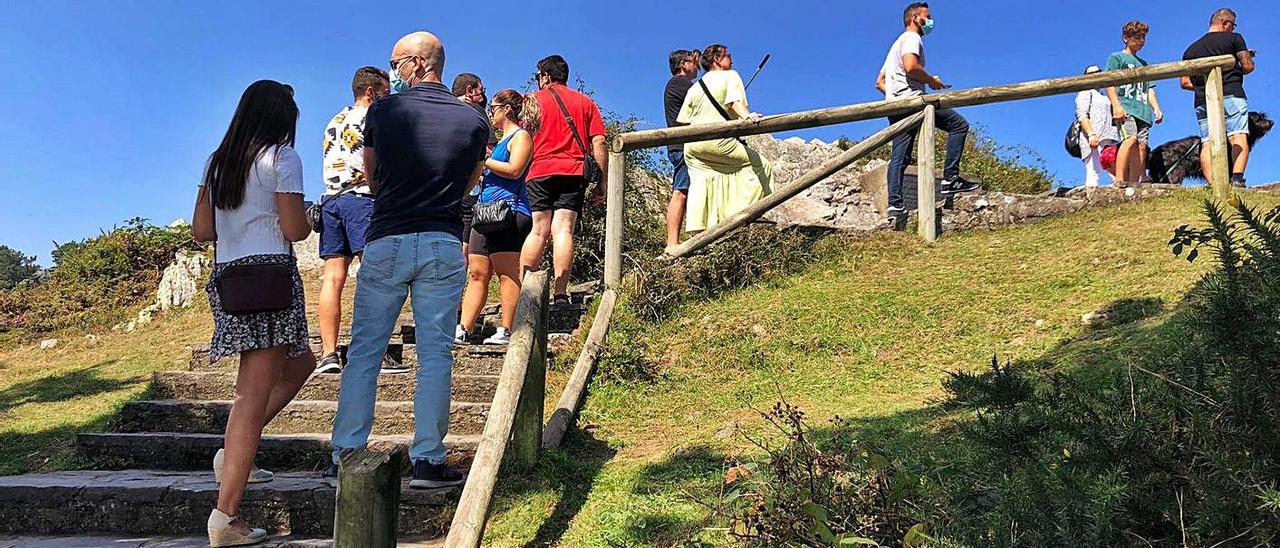 Un grupo de turistas, en el mirador del Fitu, con la barandilla de madera rota. | J. M. C.