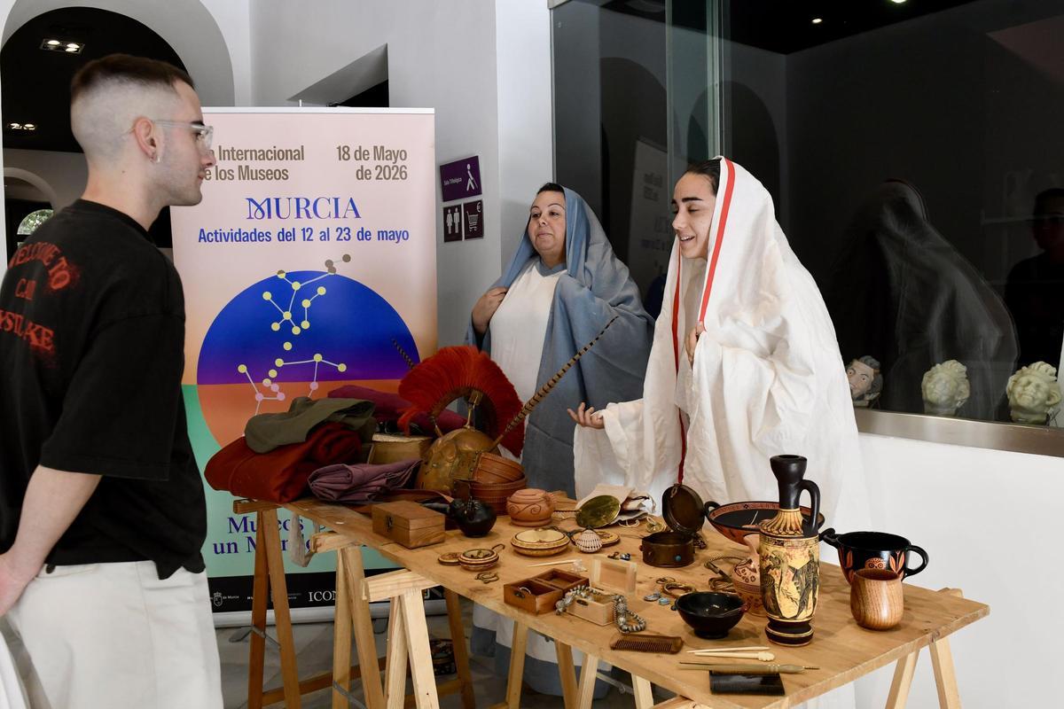 Dos mujeres recrean a comerciantes del mundo antiguo en el Museo Arqueológico de Murcia.