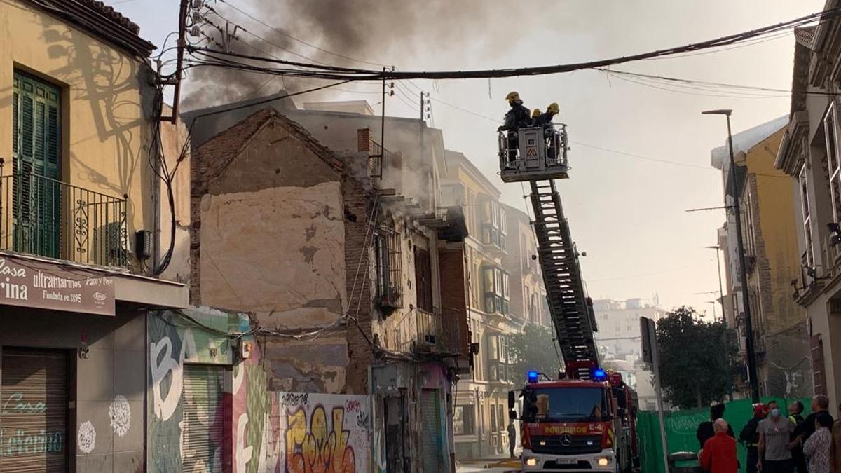 Los bomberos tratan de acceder al inmueble para sofocar el incendio.