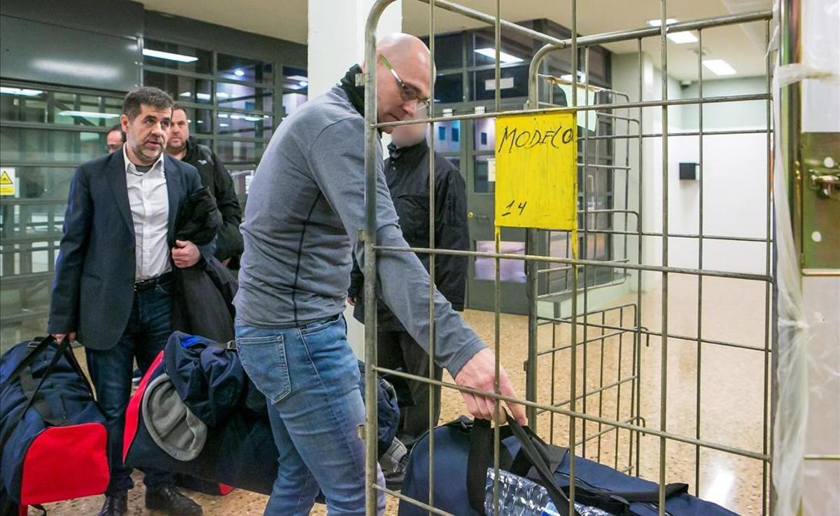 Raül Romeva coloca una bolsa en un carro, el día de su traslado a Madrid para el juicio del 1-O. Detrás de él, Jordi Sànchez y Oriol Junqueras.