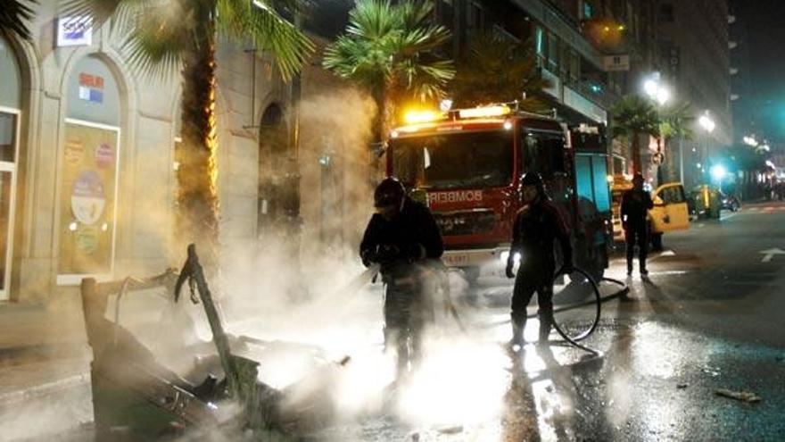 Los bomberos sofocan un contenedor en llamas en el centro de Vigo.