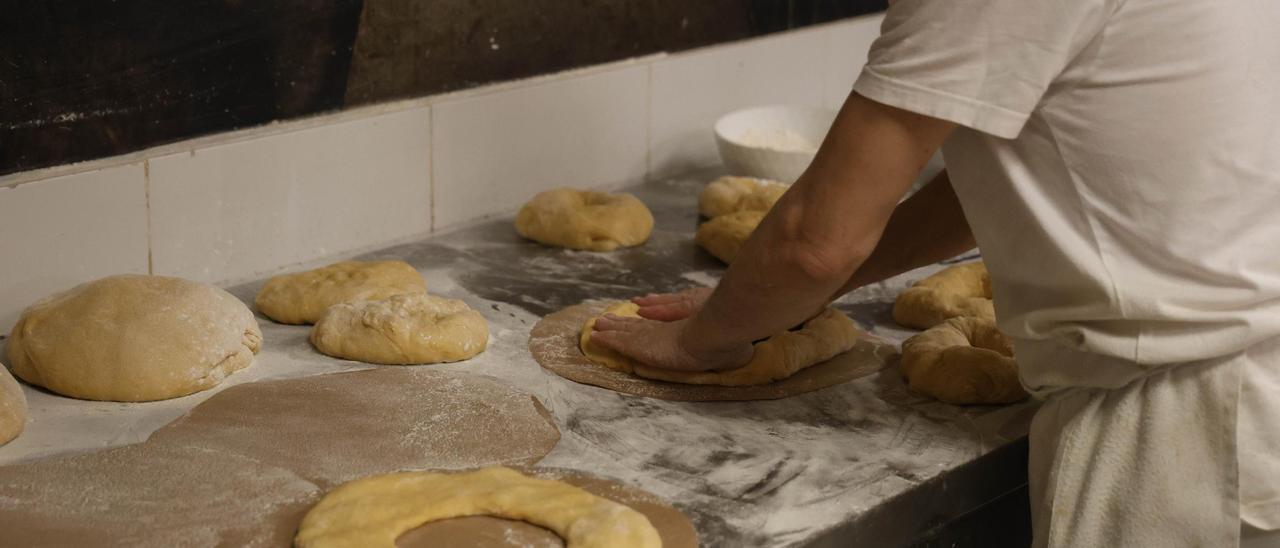 Un panadero prepara unos roscones.