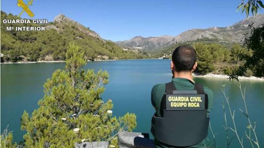 Un guardia civil del Equipo Roca frente al pantano en cuyas inmediaciones ocurrieron los robos.